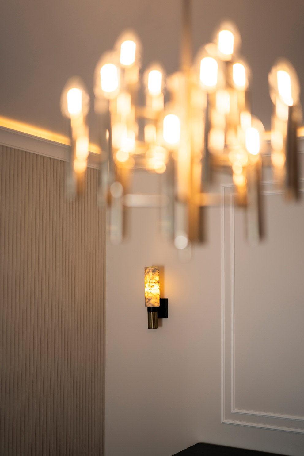 Wohnzimmer nach Kernsanierung in einem Altbau aus den 1970er-Jahren mit durchdachter Lichtplanung, indirekter Beleuchtung und verschiedenen Designleuchten für eine atmosphärische Raumwirkung.